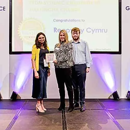 Recovery Cymru representatives celebrating charity governance recognition.